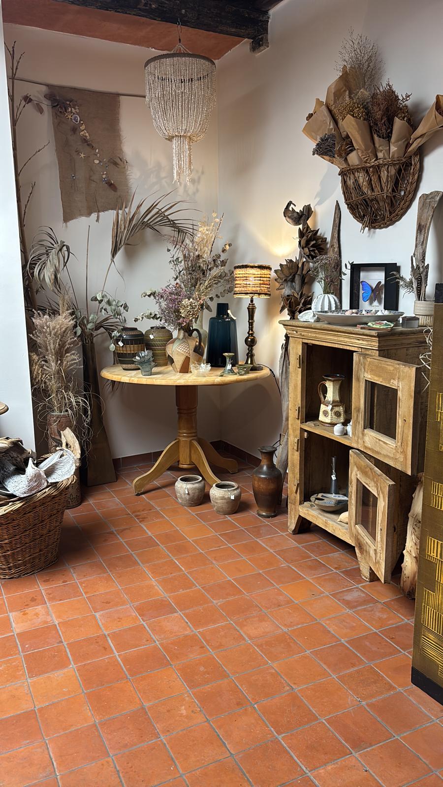 Hoek van de winkel met keramiek, gedroogde bloemen en een schelpenlamp